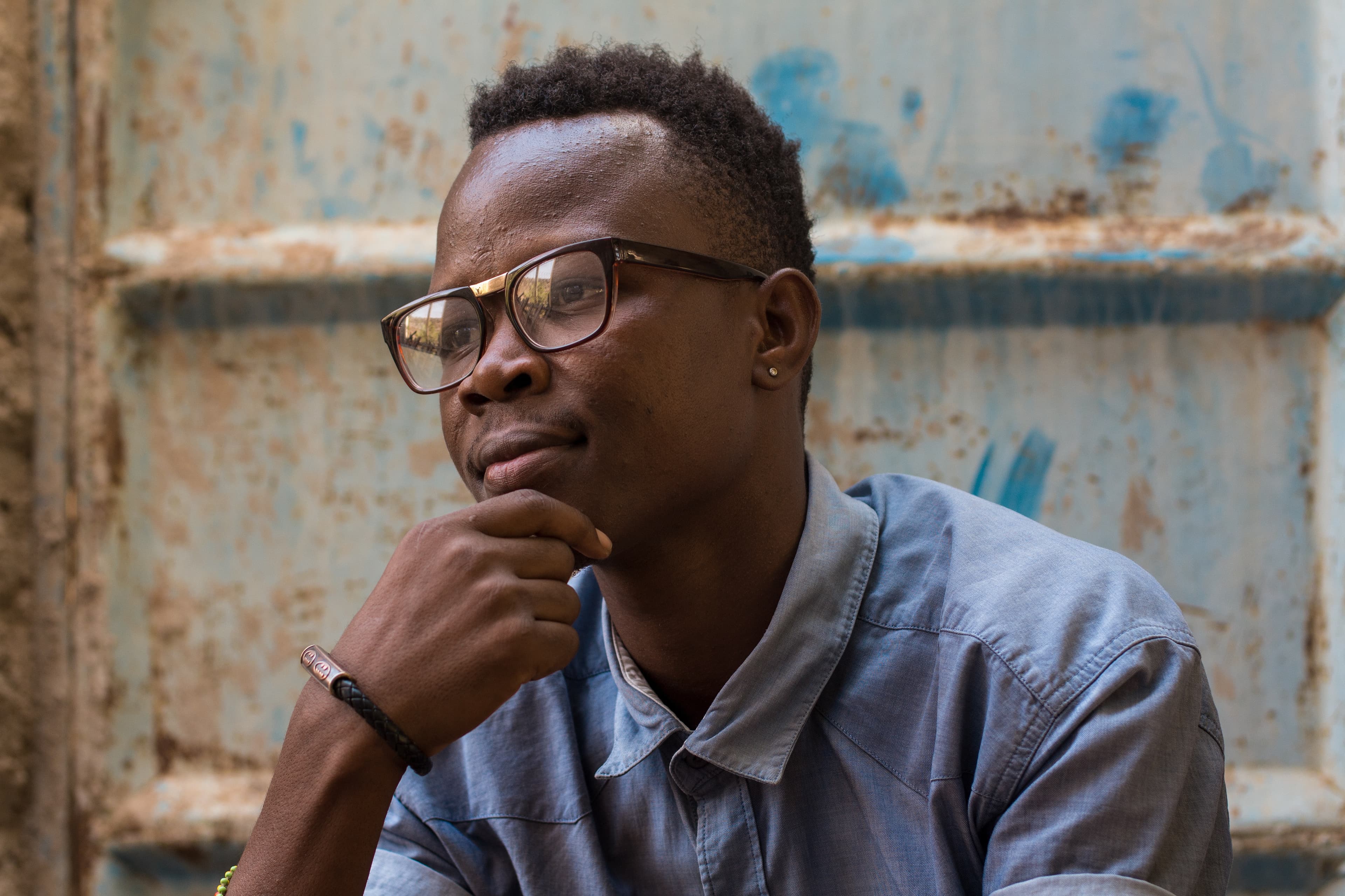 Person with glasses looking thoughtful, waiting for a delivery